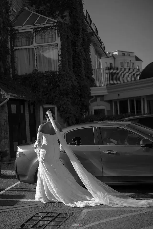 A black and white portrait of Remi beside a stone building. CameraBoss portfolio: Remi and Daniel’s Bournemouth civil wedding.