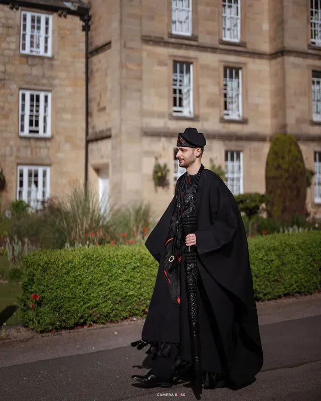 Jonny walking outside in black formal attire. CameraBoss portfolio: Jo and Jonny.