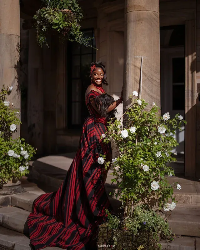 Jo standing in the doorway in red and black attire. CameraBoss portfolio: Jo and Jonny.