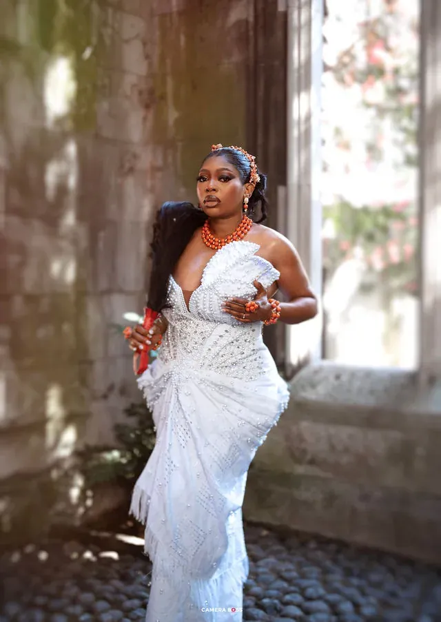 A full-length pre-wedding portrait beneath a tall window. CameraBoss portfolio: Korede Prewedding.
