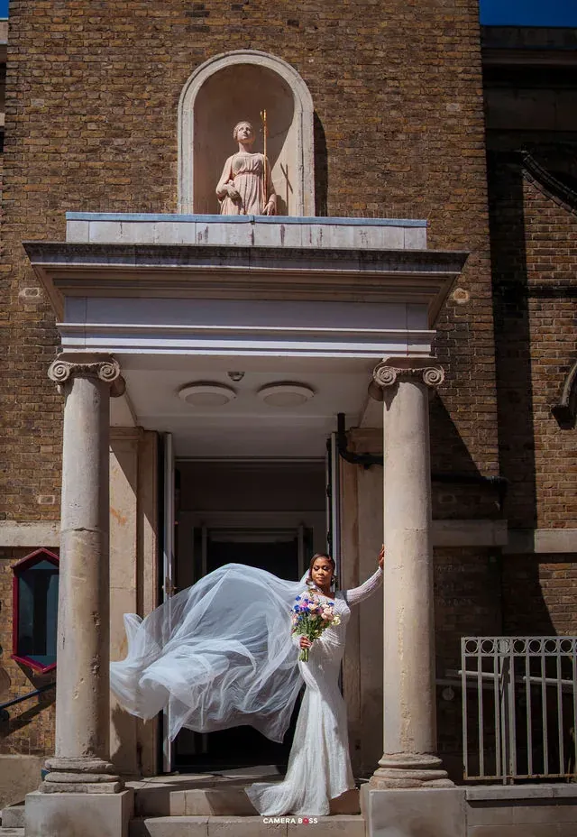 The bride turning with her veil outside the entrance. CameraBoss portfolio: Cynthia and Oswaldo.