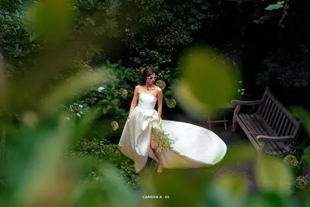 Bride in a white gown walking through a garden