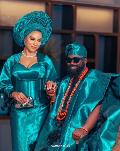Couple celebrating in matching teal Nigerian wedding attire
